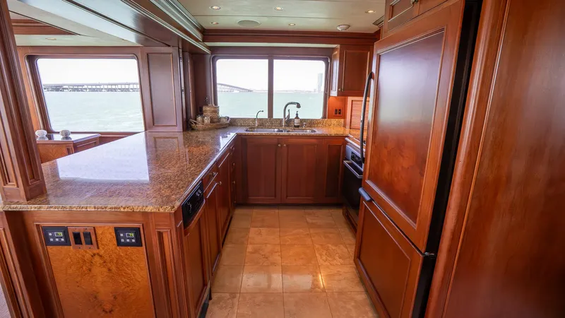  Yacht Photos Pics Luxurious kitchen interior of 1999 Burger 85 Deck house yacht with wooden cabinetry and sea view.