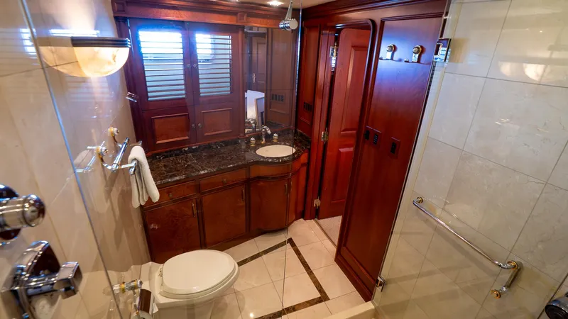  Yacht Photos Pics Luxurious bathroom in 1999 Burger 85 Deck house yacht with wooden cabinetry and marble accents.