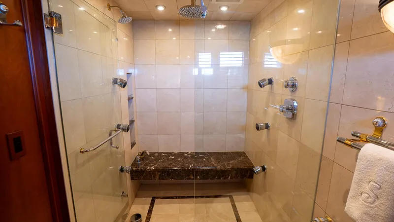  Yacht Photos Pics Luxurious shower in 1999 Burger 85 Deck house yacht, featuring marble bench and modern fixtures.