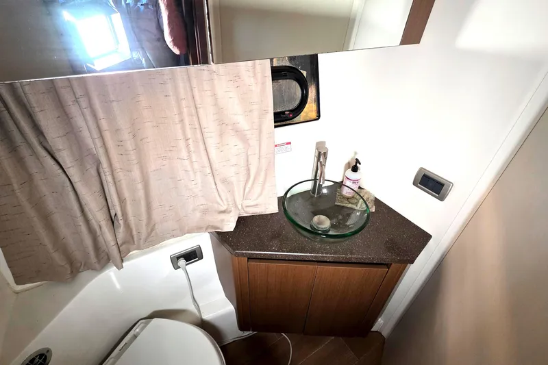  Yacht Photos Pics 2016 Sea Ray Sundancer 400 bathroom with glass sink and wooden cabinetry.