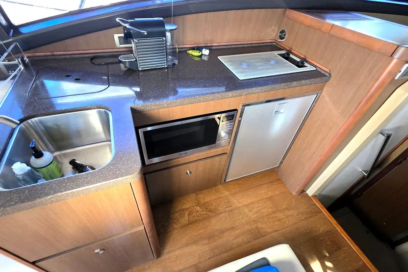  Yacht Photos Pics Compact kitchen area in a 2016 Sea Ray Sundancer 400 yacht with sink, microwave, and mini-fridge.