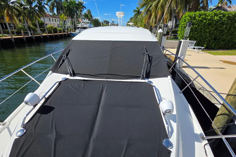  Yacht Photos Pics 2016 Sea Ray Sundancer 400 yacht docked, covered with black canvas, surrounded by palm trees.