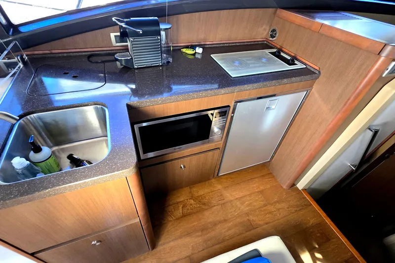  Yacht Photos Pics Compact kitchen area in a 2016 Sea Ray Sundancer 400 yacht with sink, microwave, and mini-fridge.