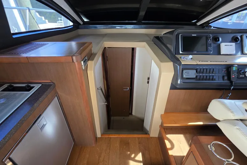  Yacht Photos Pics Interior view of 2016 Sea Ray Sundancer 400 yacht, featuring helm and cabin entrance.