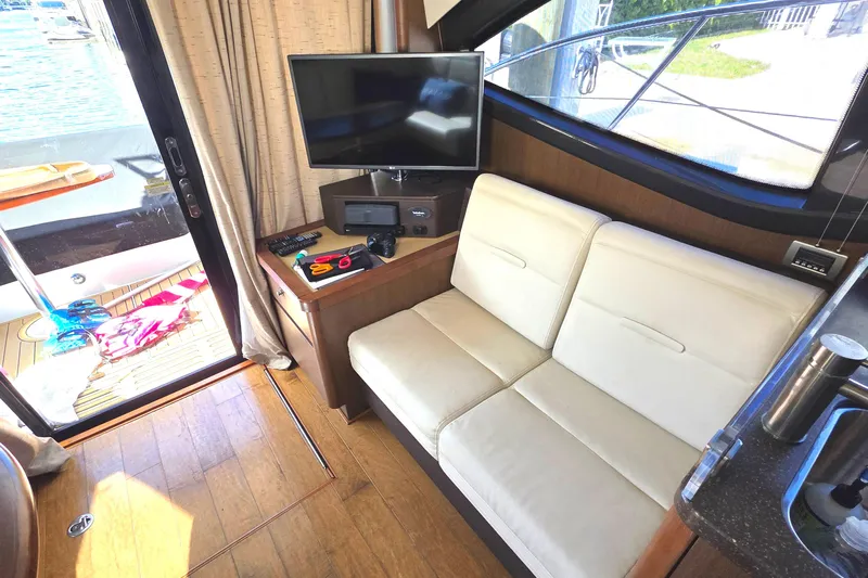  Yacht Photos Pics Interior of 2016 Sea Ray Sundancer 400 yacht with sofa, TV, and outdoor view.