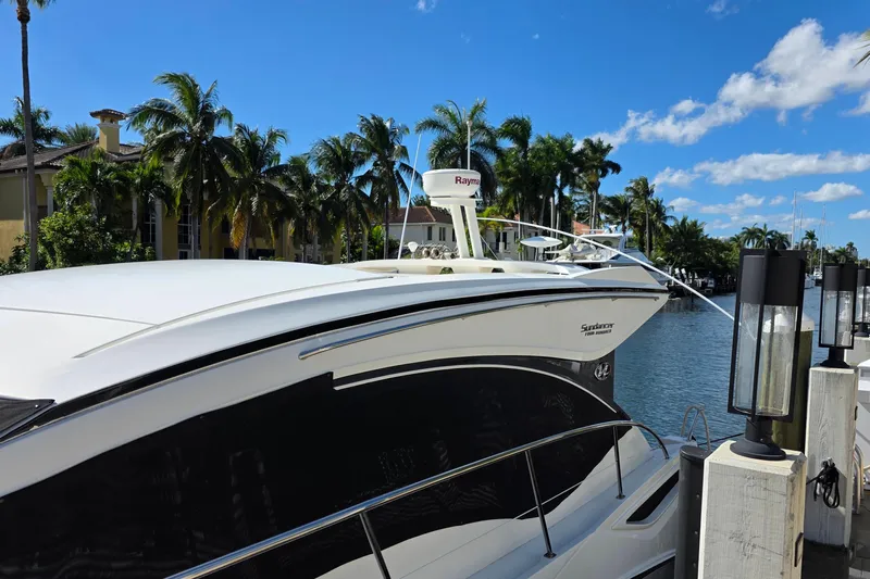  Yacht Photos Pics 2016 Sea Ray Sundancer 400 yacht docked by palm trees and waterfront homes.