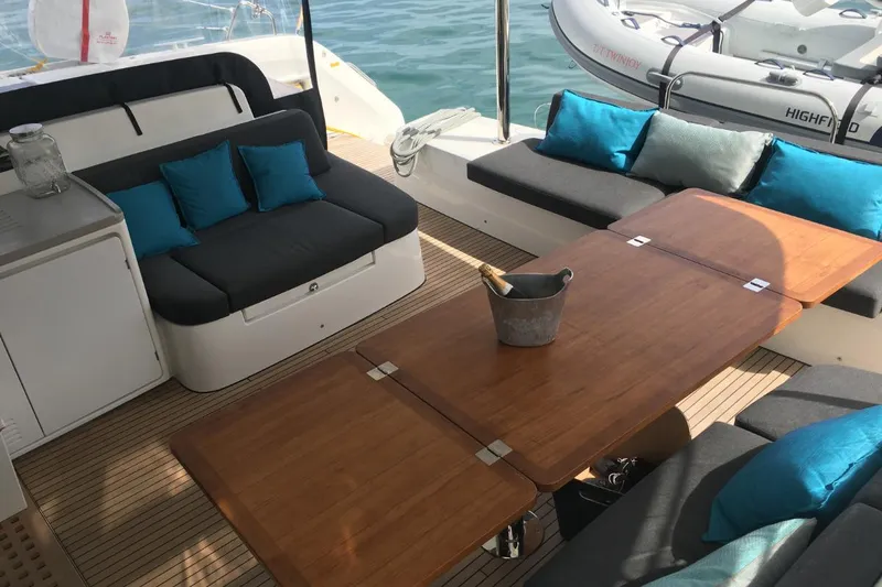 Twin Joy Yacht Photos Pics Luxurious 2019 Lagoon 50 yacht interior with elegant seating and wooden table.