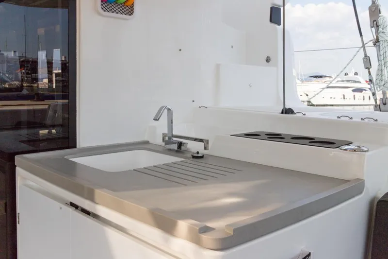 Twin Joy Yacht Photos Pics Outdoor kitchen area on 2019 Lagoon LAGOON 50 yacht with sink and countertop.