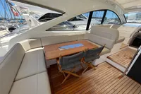 Luxury seating area on 2020 Fairline Targa 48 Open yacht with wooden table and chairs.