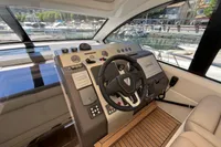 Helm of 2020 Fairline Targa 48 Open yacht with modern controls and marina view.