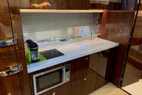 Modern galley kitchen in 2020 Fairline Targa 48 Open yacht with sleek wood cabinetry.