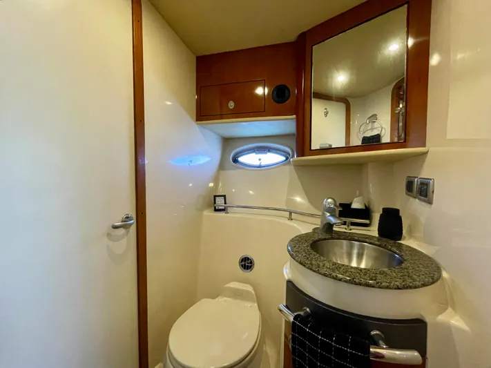 Deja Blue Yacht Photos Pics 2005 Sea Ray 390 Sundancer bathroom with sink, mirror, and porthole window.