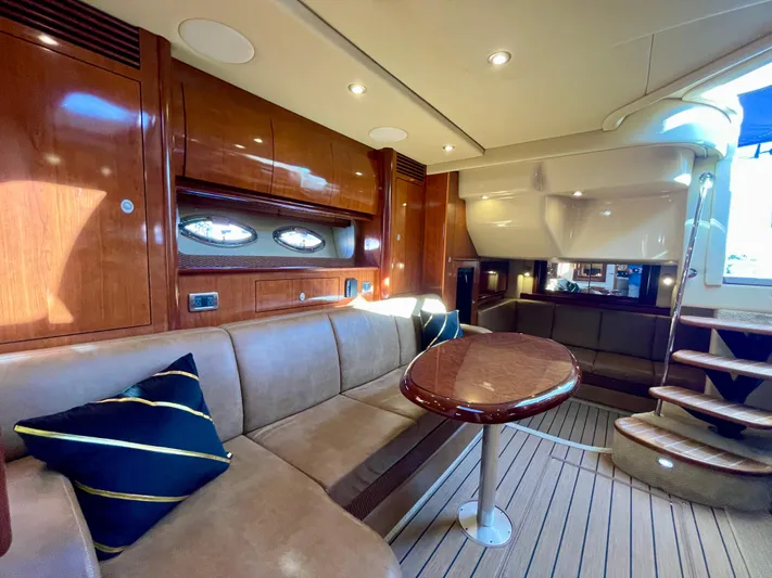 Deja Blue Yacht Photos Pics Luxurious interior of 2005 Sea Ray 390 Sundancer yacht with wood finishes and seating area.