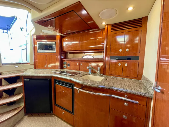 Deja Blue Yacht Photos Pics Luxurious kitchen interior of 2005 Sea Ray 390 Sundancer yacht with wood cabinetry.