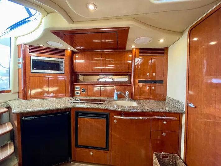 Deja Blue Yacht Photos Pics Luxurious kitchen interior of 2005 Sea Ray 390 Sundancer yacht with wood cabinetry and modern appliances.