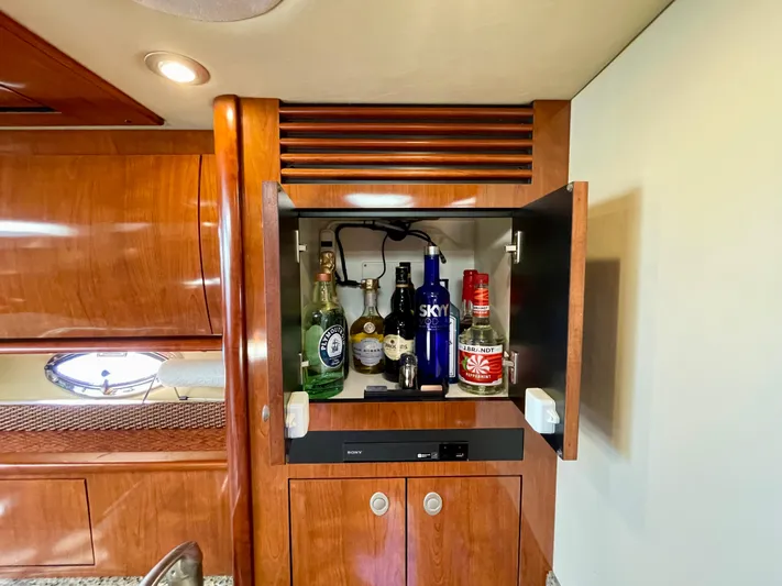 Deja Blue Yacht Photos Pics Bar cabinet inside 2005 Sea Ray 390 Sundancer yacht with assorted liquor bottles.