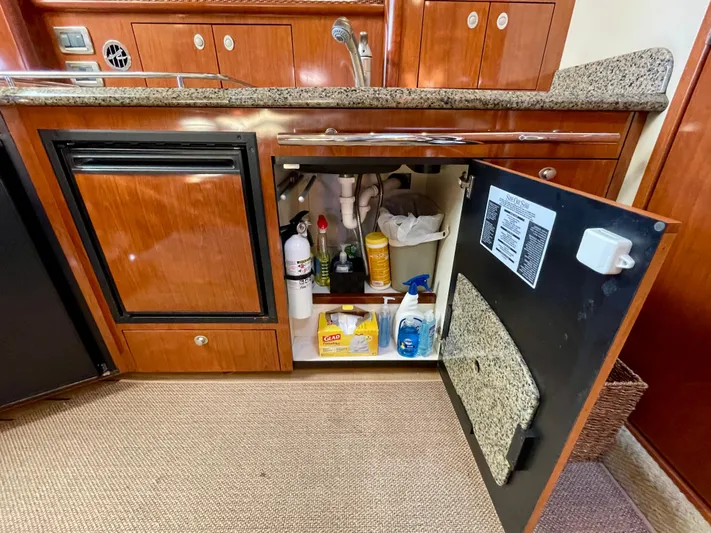 Deja Blue Yacht Photos Pics 2005 Sea Ray 390 Sundancer kitchen cabinet with cleaning supplies and fire extinguisher.