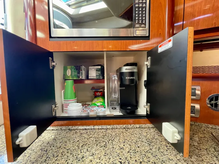 Deja Blue Yacht Photos Pics Cabinet with coffee supplies and Keurig in 2005 Sea Ray 390 Sundancer yacht kitchen.