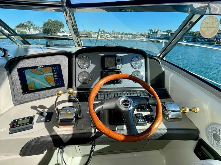 Deja Blue Yacht Photos Pics 2005 Sea Ray 390 Sundancer helm with wooden steering wheel and navigation display.