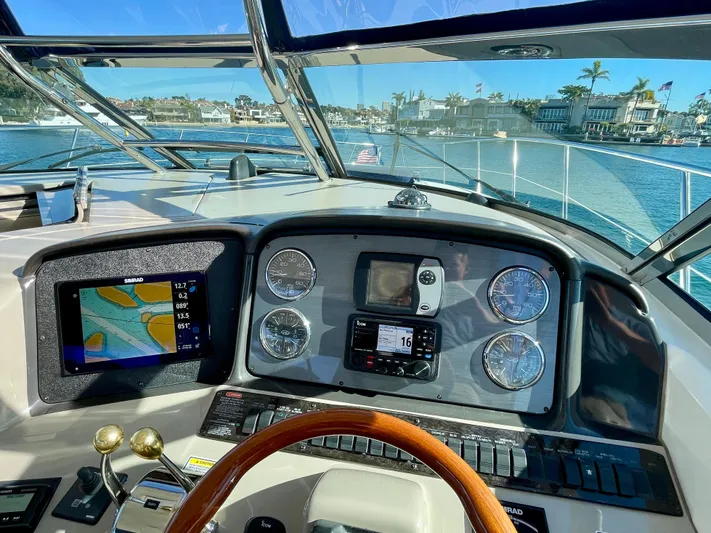 Deja Blue Yacht Photos Pics Helm of 2005 Sea Ray 390 Sundancer with navigation instruments and waterfront view.
