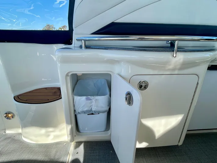 Deja Blue Yacht Photos Pics 2005 Sea Ray 390 Sundancer interior with open cabinet and trash bin.