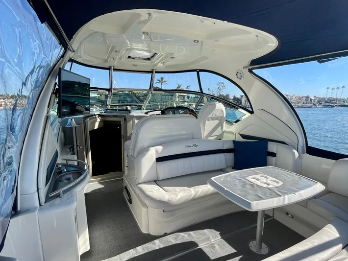 Deja Blue Yacht Photos Pics 2005 Sea Ray 390 Sundancer yacht interior with seating and table, docked by the water.