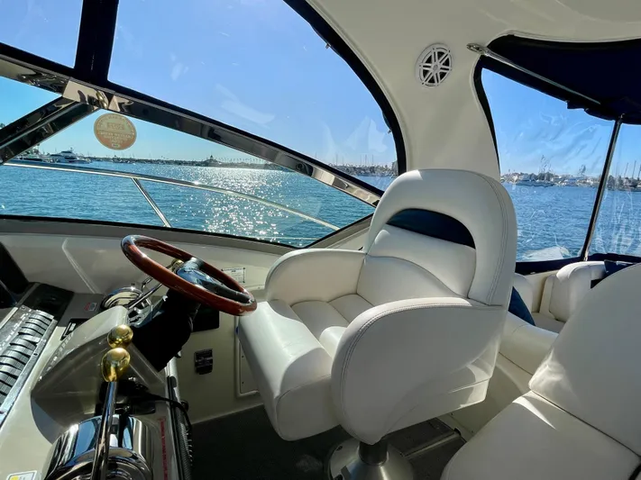 Deja Blue Yacht Photos Pics Interior view of 2005 Sea Ray 390 Sundancer yacht with helm and white captain's chair.