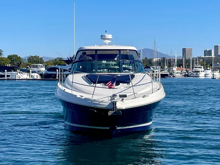 Deja Blue Yacht Photos Pics 2005 Sea Ray 390 Sundancer yacht cruising in a marina with city skyline backdrop.