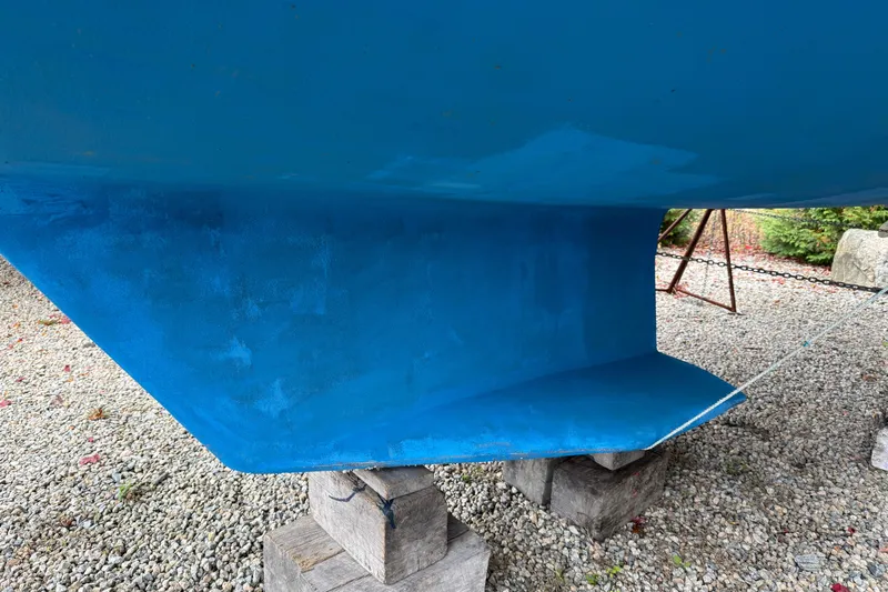 Finisterre Yacht Photos Pics Blue hull of a 2006 Catalina 36 MkII sailboat on wooden blocks.