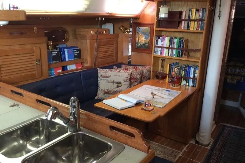Finisterre Yacht Photos Pics Cozy interior of a 2006 Catalina 36 MkII sailboat with books and nautical decor.