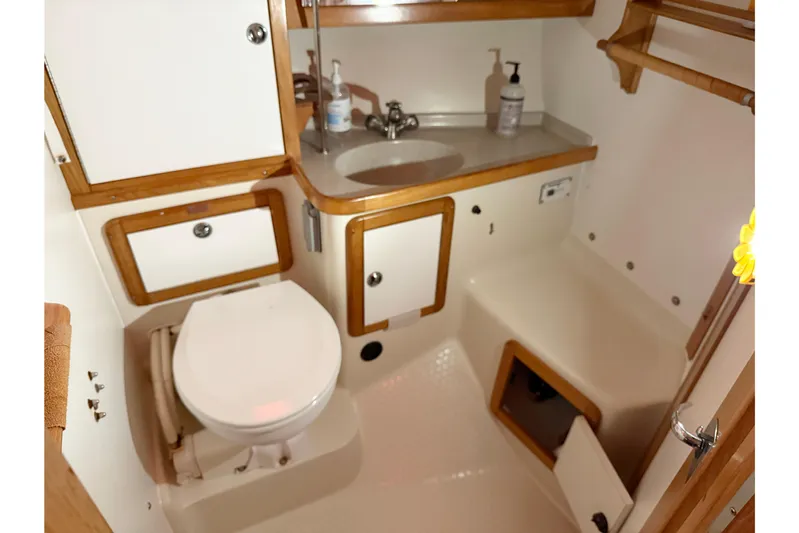 Finisterre Yacht Photos Pics 2006 Catalina 36 MkII yacht bathroom with toilet, sink, and wooden cabinetry.