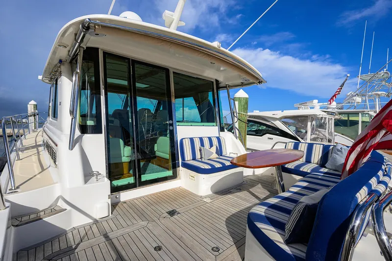 Vienna Yacht Photos Pics 2018 Sabre 48 Salon Express yacht with striped seating and wooden deck, docked under blue sky.