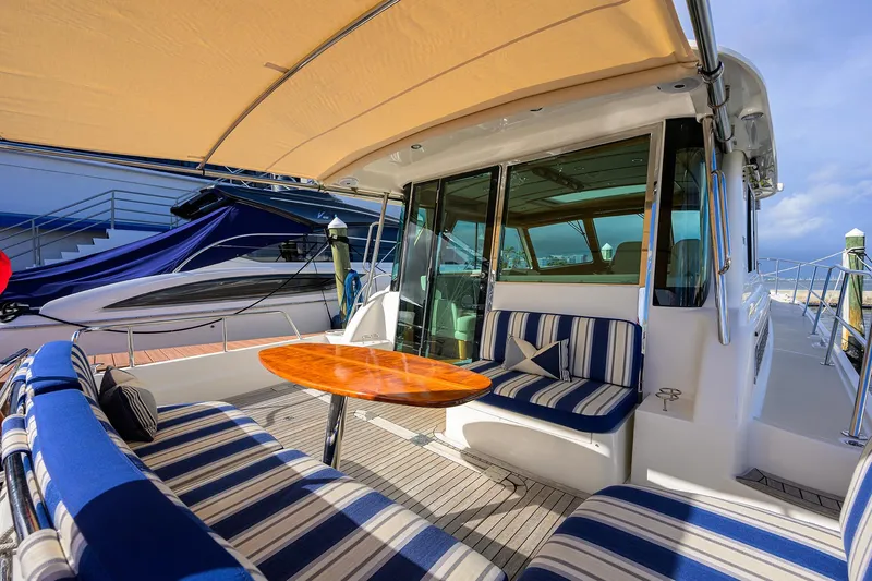 Vienna Yacht Photos Pics 2018 Sabre 48 Salon Express yacht with striped seating and wooden table on deck.