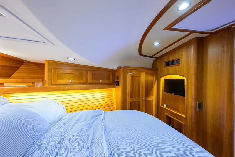 Vienna Yacht Photos Pics Luxurious 2018 Sabre 48 Salon Express cabin with wood paneling and cozy bedding.