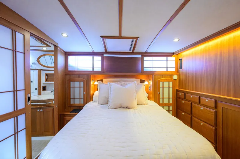Vienna Yacht Photos Pics Luxurious bedroom interior of 2018 Sabre 48 Salon Express yacht with wood paneling and ambient lighting.