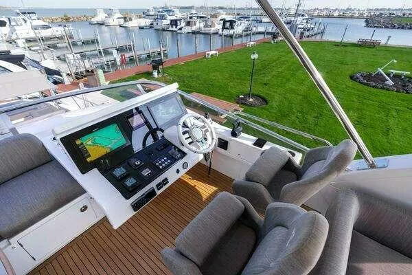  Yacht Photos Pics Flybridge of 2020 Azimut 66 yacht with helm, seating, and marina view.