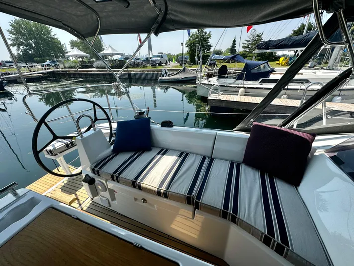  Yacht Photos Pics 2023 Beneteau Oceanis 34.1 sailboat cockpit with striped cushions, docked in a marina.