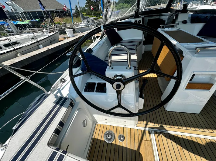  Yacht Photos Pics 2023 Beneteau Oceanis 34.1 yacht cockpit with steering wheel and teak flooring.