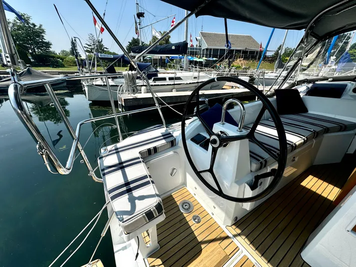  Yacht Photos Pics 2023 Beneteau Oceanis 34.1 sailboat cockpit with striped seating and steering wheel.