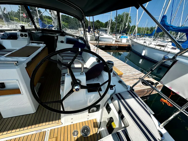 Yacht Photos Pics 2023 Beneteau Oceanis 34.1 sailboat cockpit with steering wheel, docked at marina.