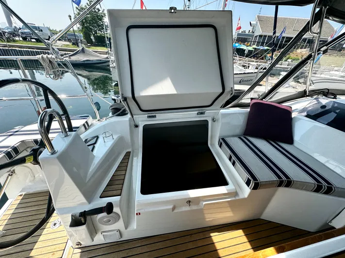  Yacht Photos Pics 2023 Beneteau Oceanis 34.1 cockpit with open storage compartment and striped seating.