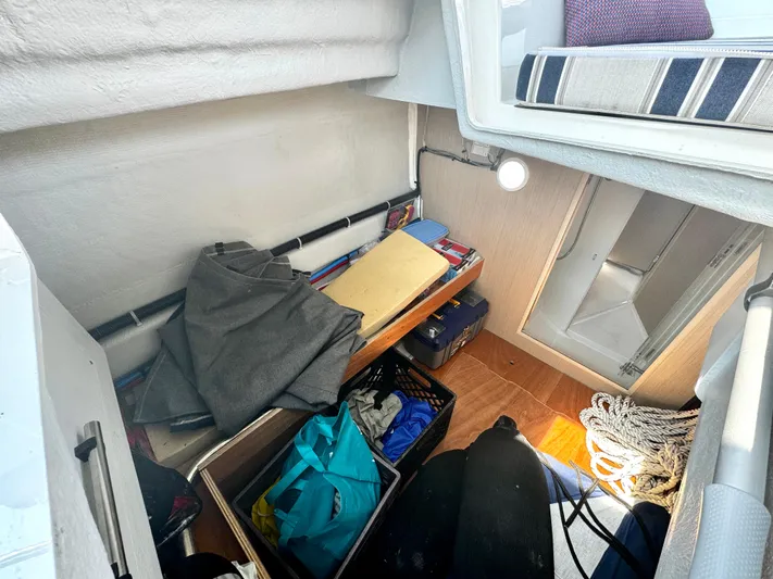  Yacht Photos Pics Interior storage area of 2023 Beneteau Oceanis 34.1 sailboat with various items and equipment.
