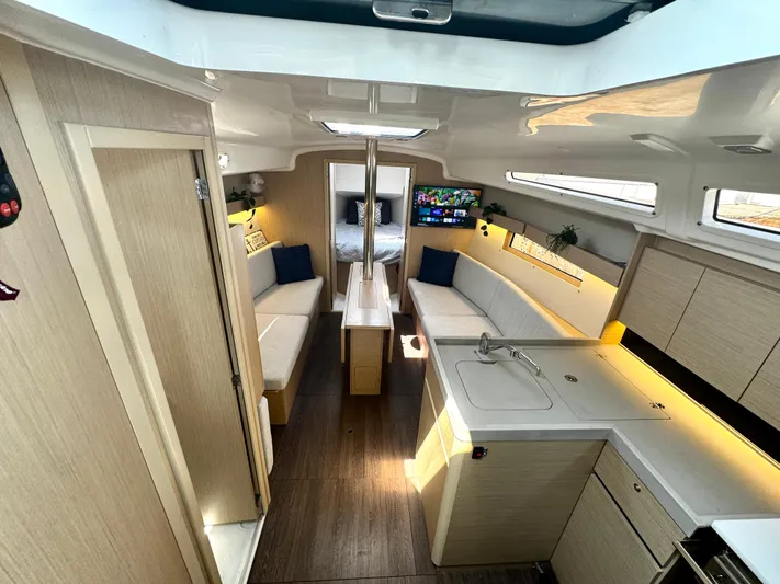  Yacht Photos Pics 2023 Beneteau Oceanis 34.1 interior with modern kitchen, cozy seating, and natural light.