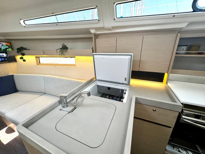  Yacht Photos Pics Modern interior of 2023 Beneteau Oceanis 34.1 yacht with sleek kitchen and seating area.
