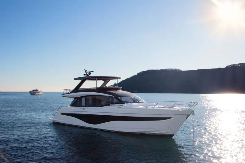  Yacht Photos Pics 2025 Princess Y72 Motor Yacht cruising on serene waters under a bright sun.