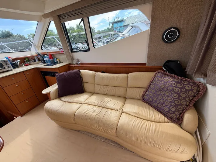  Yacht Photos Pics Interior of 2008 Silverton 33 Convertible yacht with beige sofa and kitchen area.