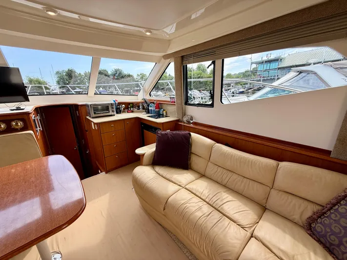  Yacht Photos Pics Interior of 2008 Silverton 33 Convertible yacht with beige sofa and wooden cabinetry.