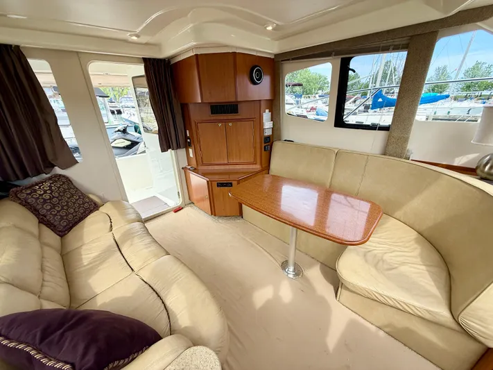  Yacht Photos Pics Interior of 2008 Silverton 33 Convertible yacht with beige seating and wooden table.