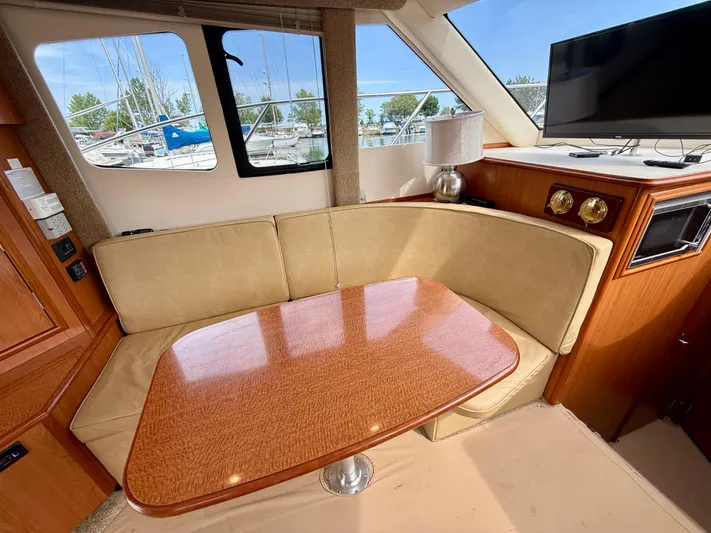  Yacht Photos Pics Interior of 2008 Silverton 33 Convertible yacht with beige seating and wooden table.
