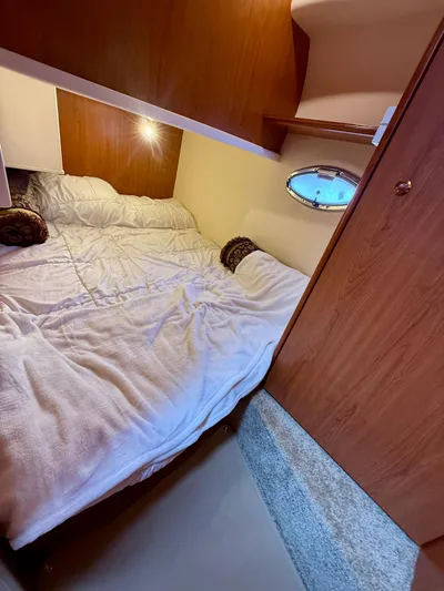  Yacht Photos Pics Cozy cabin interior of 2008 Silverton 33 Convertible yacht with bed and porthole.